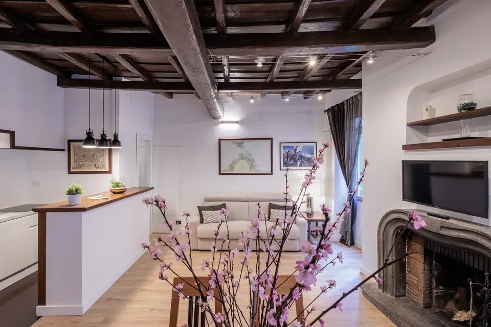 Corner of the living room with the masonry fireplace and peach blossom on the table.