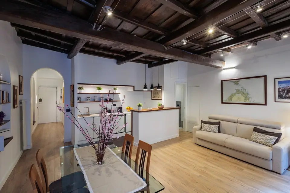 The kitchen counter opening onto the living room, with black pendant lamps.